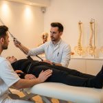 Healthcare Services Concept with Professional Medical Care and Patient Support | CR Diario Therapist adjusts a patient in a strap-based traction setup during a physical therapy session.