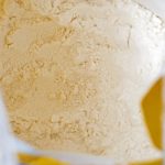 Close-up top view of a bag of white wholemeal flour | CR Diario Bag of pale flour, close-up inside a plastic package on a kitchen counter.